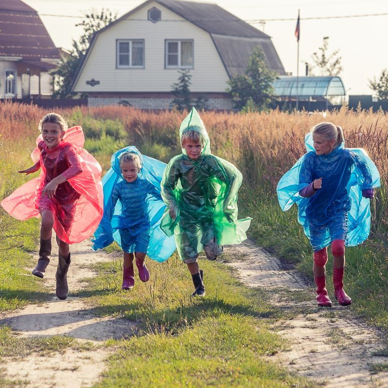 kids in rain ponchos running away from farm