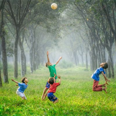 Kids playing ball in meadow