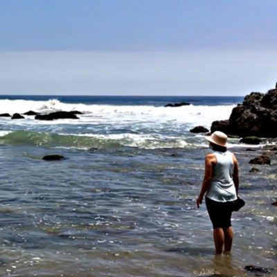 Woman standing looking across ocean