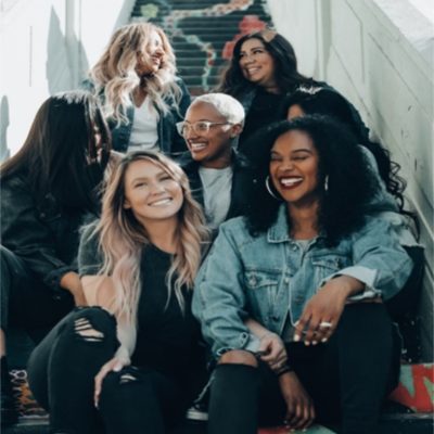 group of women sitting on stairs smiling